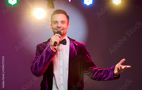 Obraz na plátně Presenter singer singing with microphone on stage