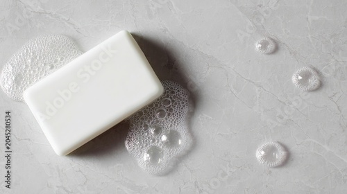 White soap bar on wet marble with bubbles