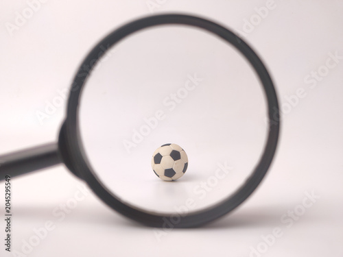 Foto A small black and white soccer ball is viewed through the center of a black magn