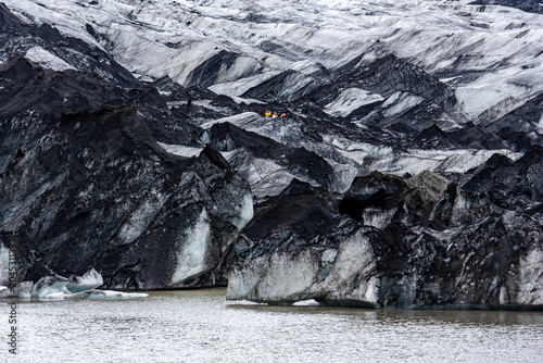Billede på lærred Solheimajokull glacier tongue with black volcanic ash streaks meeting glacial la