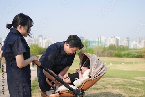 Foto Two women attend to a baby in a stroller outdoors