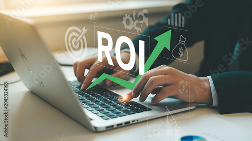 Businessman analyzing financial growth on laptop with roi graph and statistics