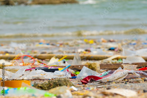 Foto Polluted beach with plastic waste and garbage washed up on the shore, environmen