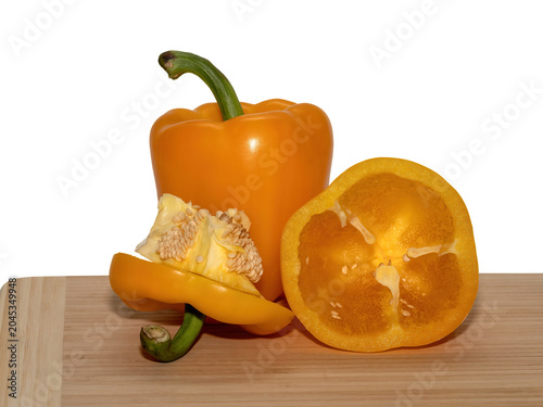 Orange bell pepper whole and sliced on cutting board