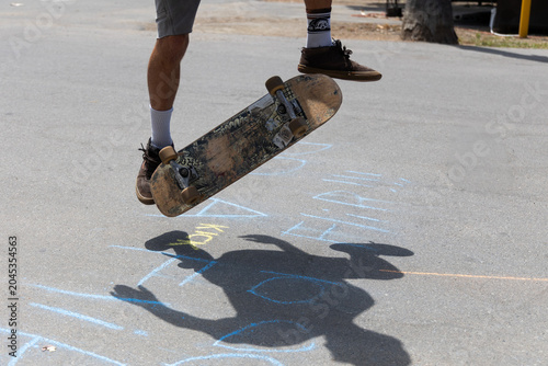 Принти на полотні Close-up of a skateboarder doing tricks on a concrete road, kickflip