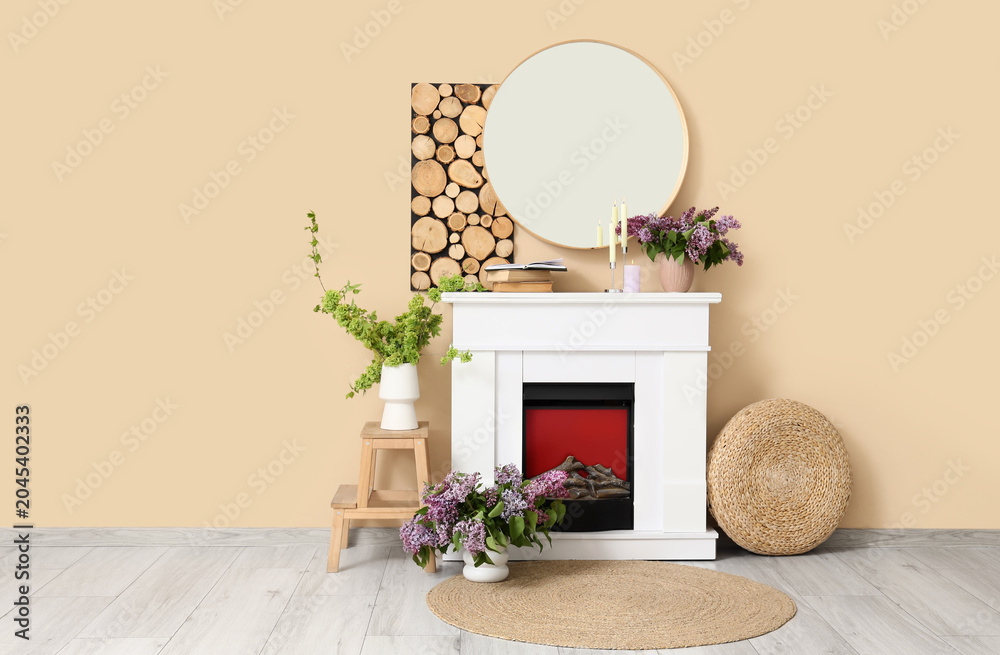 Obraz premium Interior of living room with fireplace, mirror and spring branches in vases
