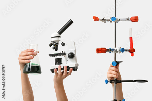 Female hands with modern microscope, test tube stand and laboratory glassware...
