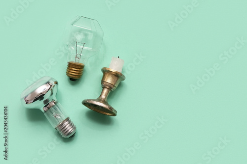 Foto Light bulbs and candle on turquoise background