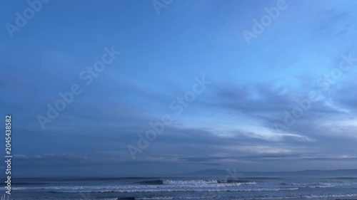 夕暮れの青空と薄雲と波打ち際と山並みが広がる湘南の海岸