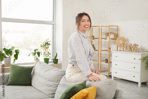 Happy young woman sitting o...