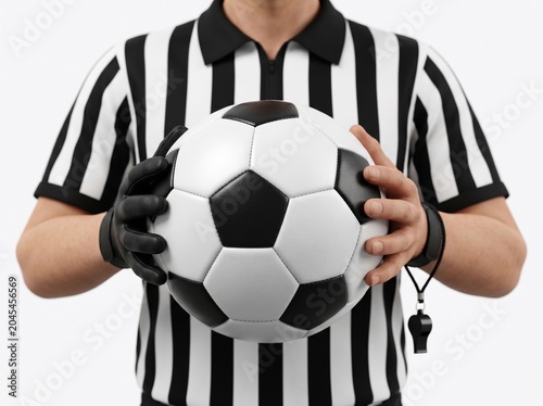 Referee holding soccer ball and whistle.