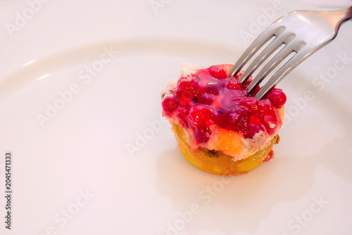 Slika na platnu A delectable mini dessert topped with vibrant red berries on a pristine white plate