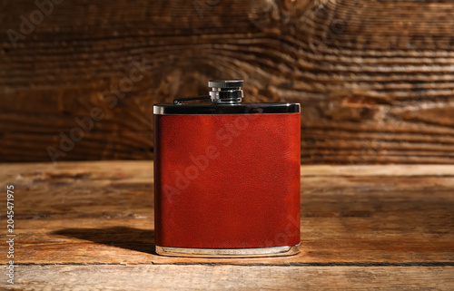 New hip flask on wooden bac...