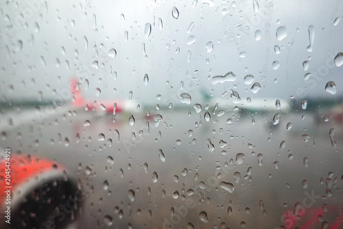 Fotografía The image depicts an airplane window during a rainstorm, with raindrops clinging to the surface