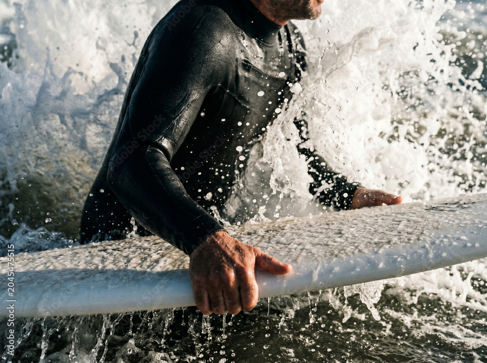 Fototapeta premium Man in wetsuit surfing ocean waves.