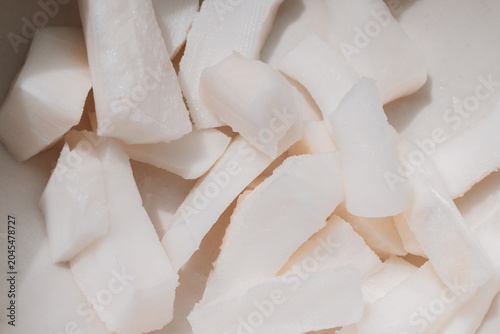 Obraz na płótnie Close-up of freshly sliced white yucca pieces on a smooth surface