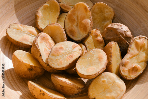 Foto Golden roasted potatoes in a wooden bowl basking in warm sunlight