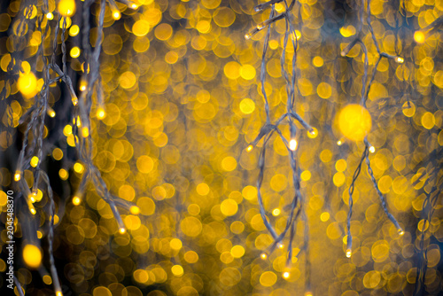 golden fairy lights hanging with heavy bokeh background. super warm and festive glow for christmas or new year party vibe