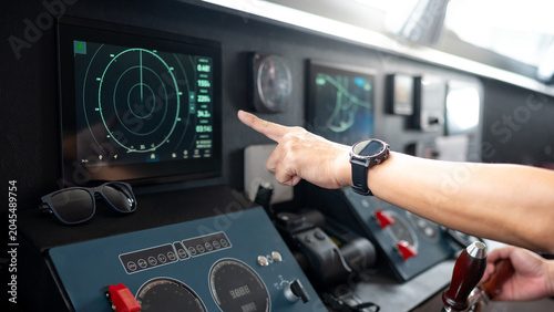 Bild auf Leinwand Captain hand with wristwatch pointing at marine radar monitor screen or GPS navigation map on boat dashboard