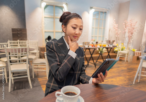 Quadro su tela スマートフォンを見るスーツの女性