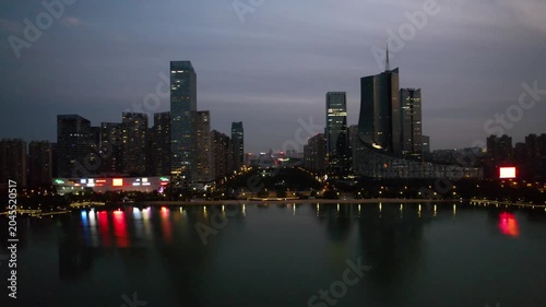 Illuminated modern city skyline at dusk over waterfront