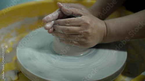 Hands Shaping Clay on Pottery Wheel in Ceramic Workshop