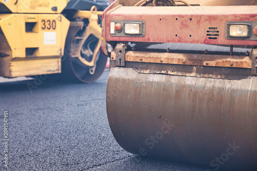 Fotografie Workers are engaged in asphalt paving on a city street using heavy machinery