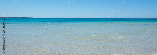 Turquoise ocean water meeting white sand beach