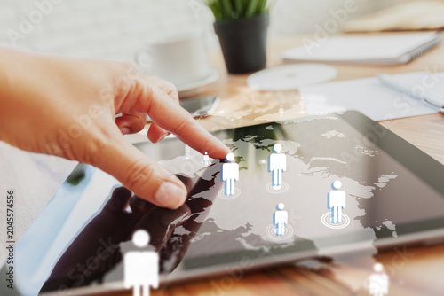 Touching a tablet screen showing customer relationship management data in an office setting