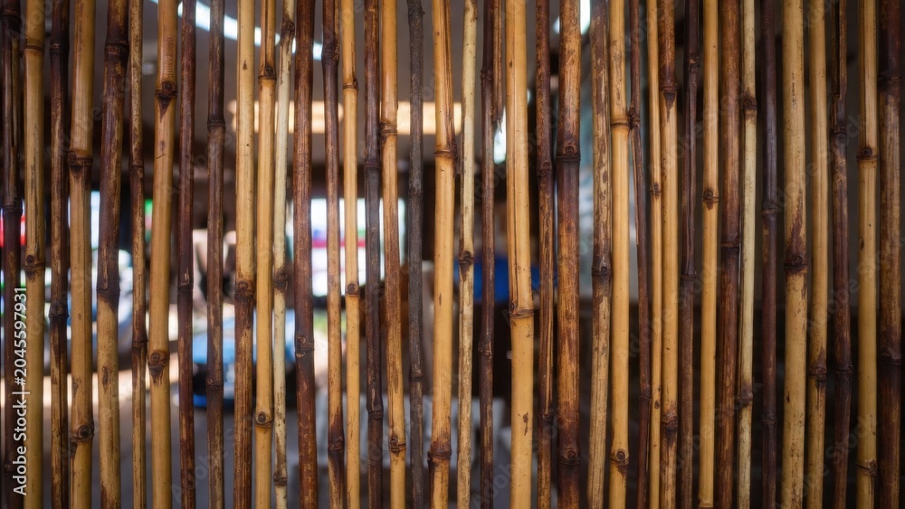 Obraz premium Vertical bamboo rods forming semi transparent market partition