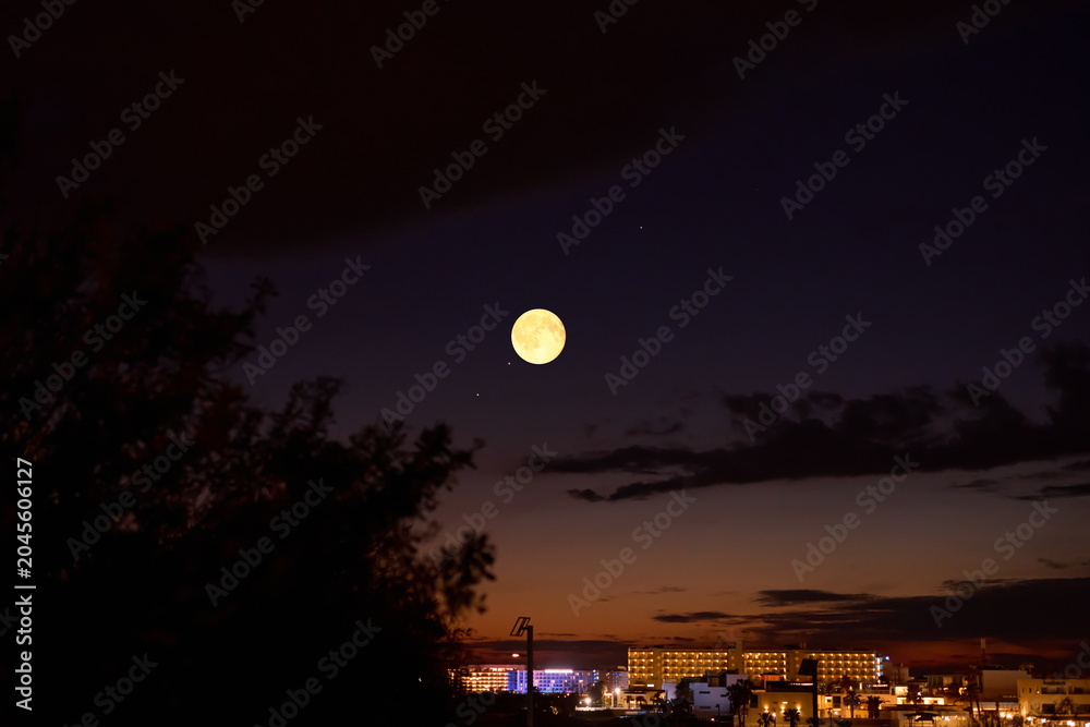 Obraz premium Full Moon with urban silhouettes.
