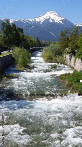 Melting snow in the mountains, fast streams of cold clear ice water flow through thawed snow on rocks in Bulgaria.