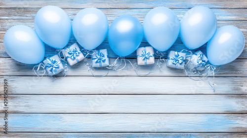 Festive Blue Balloons and Gifts on a Rustic Wooden Surface.