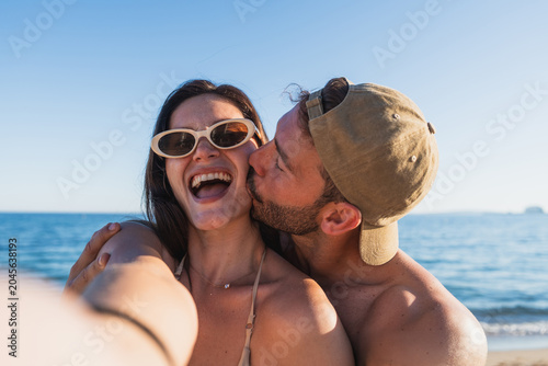 Canvastavla Young couple enjoying romantic kiss on summer beach