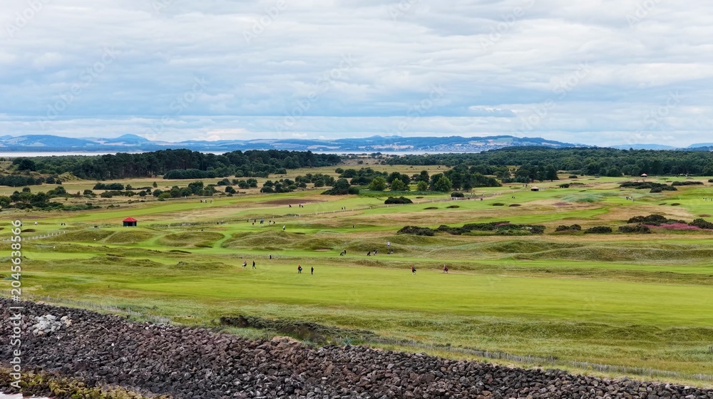 Fototapeta premium Aerial View of Golfers Walking on Carnoustie Links Under Overcast Sky