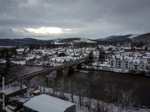 Foto Old stone bridge over Dee river aerial view in Ballater by winter, Scotland