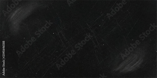 Photos A weathered, dusty blackboard displays subtle smudges and faint white streaks, hinting at past lessons and creative endeavors, set against a dark, textured background