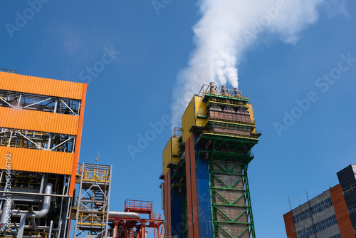 Tableau sur toile Industrial Power Plant with Steam Emissions and Blue Sky