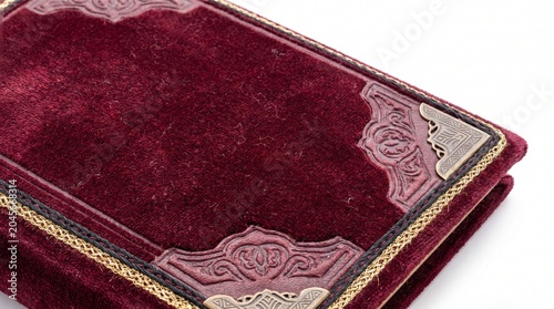 Vintage maroon leather notebook with floral embossed cover resting on white surface