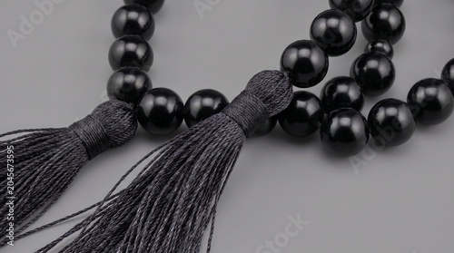 Elegant beaded necklace with tassel charm on neutral background minimalist jewelry accessory
