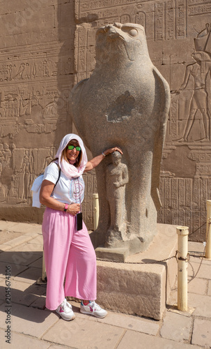Billede på lærred Woman tourist posing with ancient horus statue in edfu temple