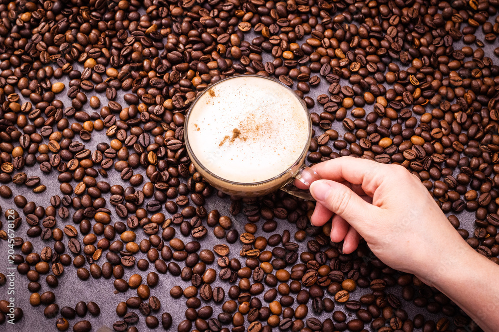 Naklejka premium Hand holding a round soap bar above coffee beans