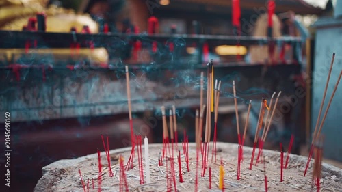Burning incense sticks with smoke at Buddhist temple ritual in Thailand, Incense smoke during spiritual worship and offering at temple altar 4k