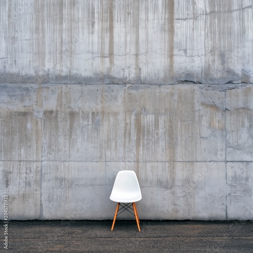 Simple White Chair Against a Blue Wooden Wall in a Minimal Design Setting