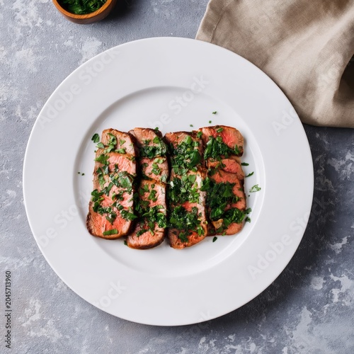 Freshly Cooked Steak Served on a White Plate With Herbs in a Dining Setting