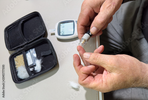 Φωτογραφία Hands performing blood glucose test with glucometer and lancet device