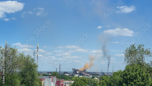 Fotografia An industrial zone with factory buildings and smoke rising into the sky