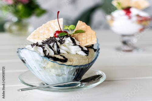 banana split ice cream sundae dessert on white table in outdoor garden cafe
