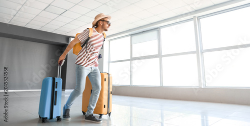 Young man with luggage at t...