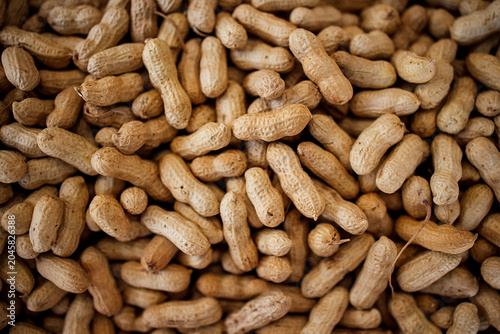 Tableau sur toile Raw, unprocessed peanuts in their shells scattered on a surface, showcasing thei